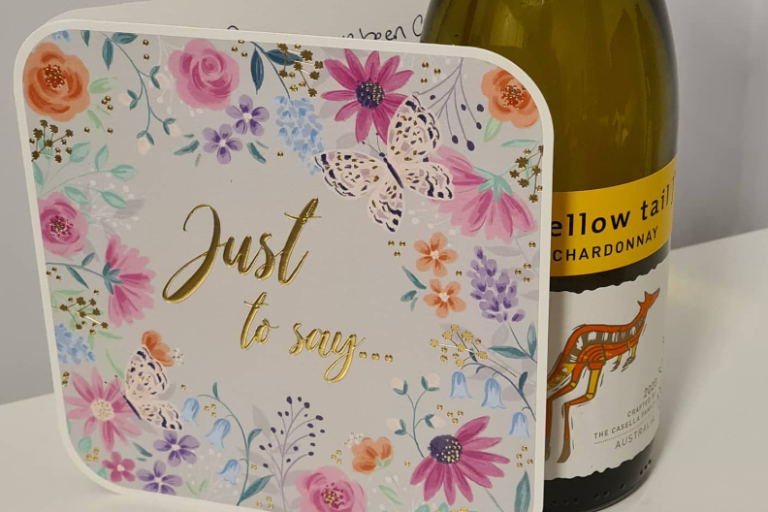 A decorative card with floral patterns and the text "Just to say..." beside a wine bottle.