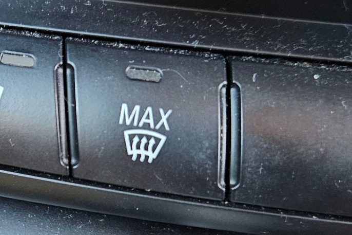 Button with "MAX" label and icon indicating front windshield defrosting feature.