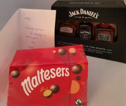 A box of Maltesers next to a Jack Daniel's gift card and a handwritten note.