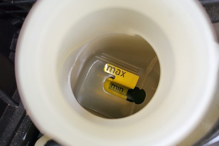 A clear container with a yellow label and a black object inside.