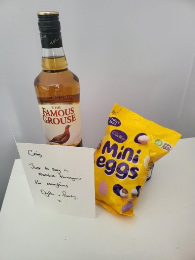 Bottle of whiskey beside a pack of Mini Eggs and a note with instructions.